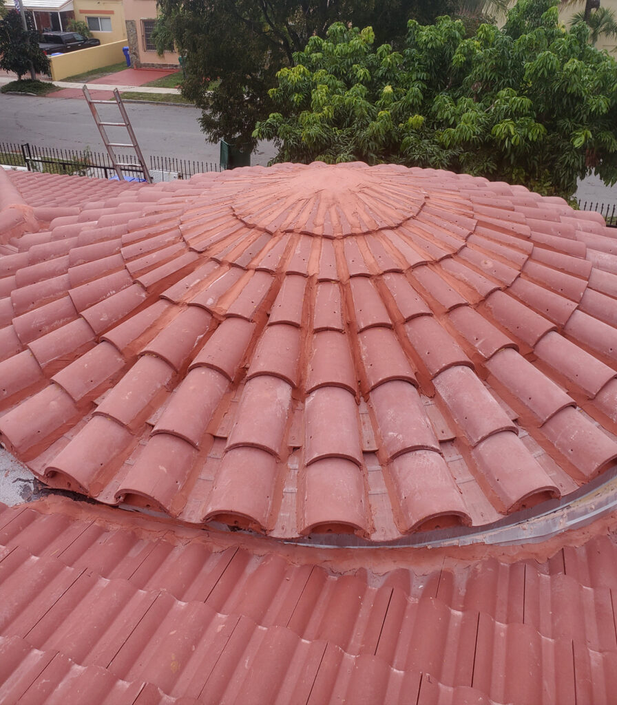 Top of a round Spanish tile roof being installed.